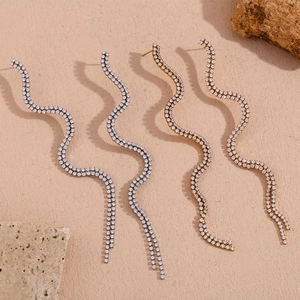 Detail of elegant S-curve wavy earrings with double-row sparkling crystals in gold and silver