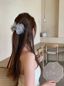 Primo piano di una molletta per capelli floreale in tessuto indossata da una modella
