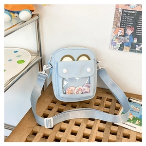Detail view of light blue ita bag featuring a bear ear design and clear display pocket
