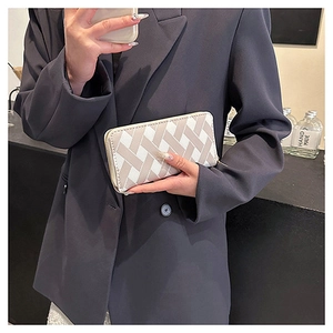Close-up of beige geometric cross pattern on a long zip-around wallet for women