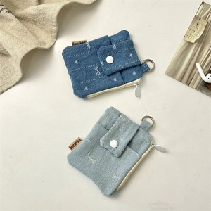 Detail of denim card holders in light and dark blue with metal zipper and hanging ring