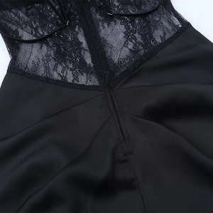 Détail de dentelle noire sur robe en satin montrant le savoir-faire et la texture soyeuse