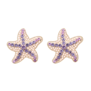 Boucles d'oreilles étoile de mer avec perles et strass violets sur fond blanc de style océan