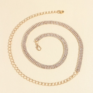 Détail d'une chaîne de corps dorée avec strass brillants et fermoir mousqueton réglable