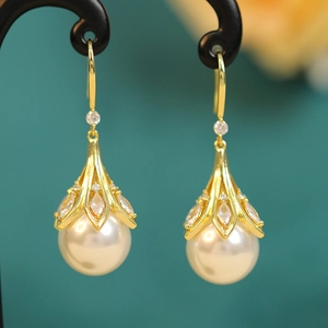 Detailed view of elegant gold drop earrings with marquise zircons and round pearls