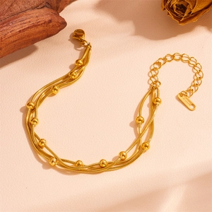 Macro view of triple-layer stainless steel snake chain with gold bead accents and lobster clasp