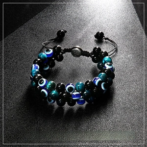 Detail of double-layer healing crystal bracelet with evil eye bead and tiger eye stones