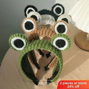 Nahaufnahme von gestrickten Frosch-Stirnbändern in Grün, Beige, Kaffee und Schwarz