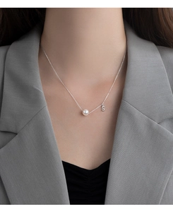 Detailed view of S925 silver necklace featuring a white pearl and sparkling letter S pendant