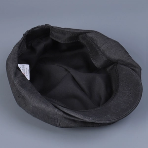 Detailed interior of a black newsboy cap featuring fabric lining and adjustable elastic band