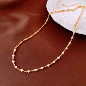 Detail of aquamarine pearl crystal necklace featuring gold bamboo joints and white beads