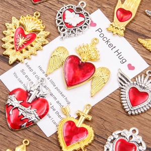 Assorted red heart Pocket Hug pendants with golden details and English gift card on wood