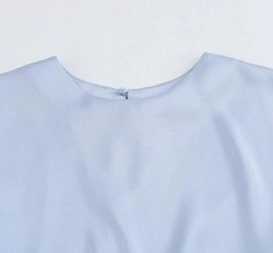 Detail of light blue satin dress neckline with a matching fabric-covered button