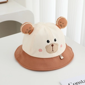 Dettaglio cappello da sole per neonati con orecchie da orso e viso ricamato