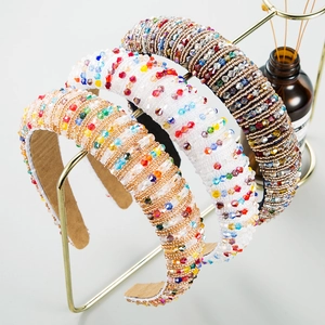 Detailed macro view of three handmade baroque crystal beaded headbands on a golden stand