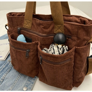 Detail of brown corduroy multi-pocket crossbody bag with zipper storage features