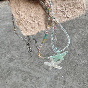 Detail of colorful beads and starfish charms on a summer beach style necklace