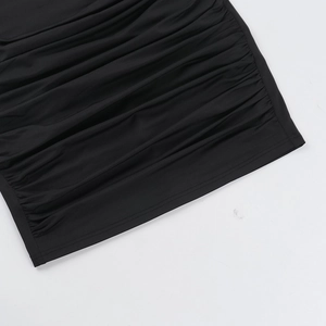 Detailed view of black ruched fabric texture with elastic pleated design on a slim dress