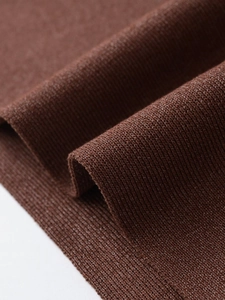 Macro shot of dark brown ribbed knit fabric showing metallic thread texture and details