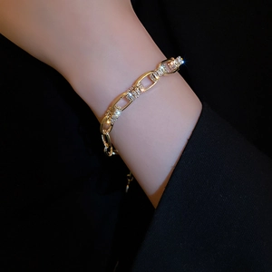Nahaufnahme des goldenen Gliederkettenarmbands mit Zirkonia-Kristallen am Handgelenk