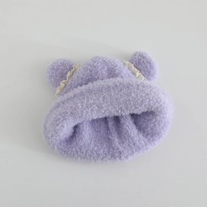 Detailed macro view of purple plush knit baby hat with bear ears and lace trim