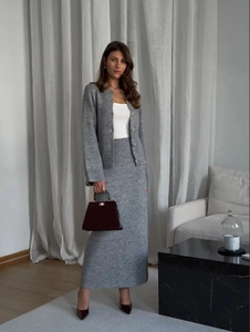 Detail of the grey knit cardigan and slim skirt set featuring high-quality fabric texture