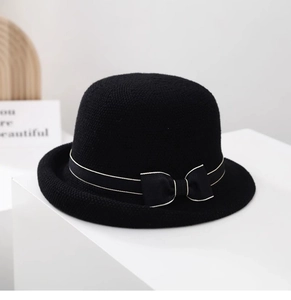 Dettaglio ravvicinato di un cappello da sole nero in maglia con fiocco e tesa arrotolata
