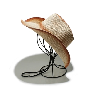 Detail showing the brown gradient brim and woven texture of the straw cowboy hat