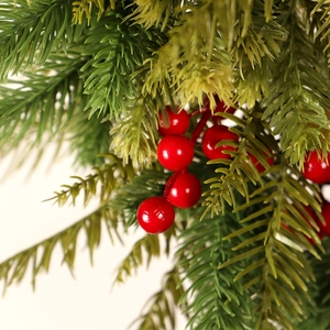 Christmas wreath with artificial green pine needles and vibrant red berries on a white background