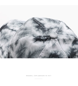 Close-up of tie-dye baseball cap featuring button top and fine six-line stitching detail