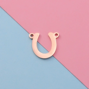 Rose gold horseshoe-shaped stainless steel connector with double loops on bicolor background