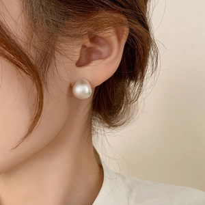 Elegant white teardrop pearl earrings on female model with minimalist matte finish aesthetic