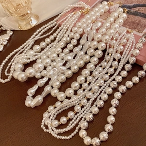 Exquisite pearl necklaces set with baroque shapes and gold hardware on a wooden table