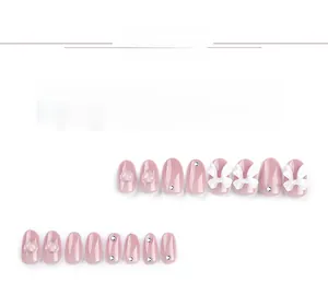 Détail de faux ongles vieux rose avec nœuds blancs 3D, cœurs et strass brillants