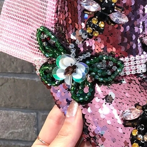 Macro detail of pink sequins baseball cap with beaded butterfly and bee rhinestone accents