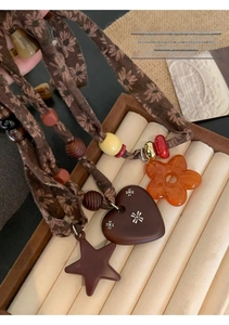 Detailed close-up of floral cotton linen cords with resin star pendants on jewelry box