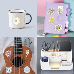 Waterproof Daisy floral stickers shown applied on mug, notebook, ukulele and desk storage