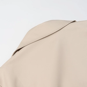 Dettaglio macro delle cuciture del colletto e della trama del tessuto del trench beige