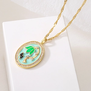 Golden necklace with blue enamel tree pendant and shimmering crystals on white background