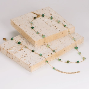 Elegant layered gold chain necklace featuring multi-size green beads on stone podiums