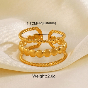 Detail of adjustable golden triple-layer ring with beaded texture on beige silk