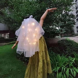 Detailed view of white multilayered kids glowing veil with warm LED string lights