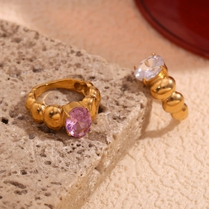 Detailed close-up of gold beaded rings featuring pink and white oval gemstones
