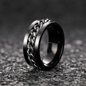 Detail view of rotatable silver cuban chain on a matte black stainless steel spinner ring