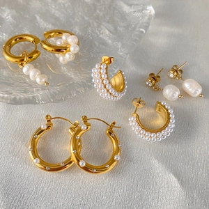 Dettaglio ravvicinato di vari orecchini a cerchio placcati oro 18K con perle barocche