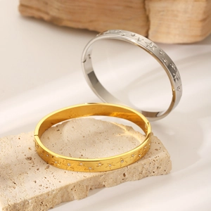 Polished gold and silver star-patterned stainless steel bracelets with inset crystals