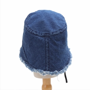 Detailed view of the frayed raw edge and denim texture on the blue bucket hat