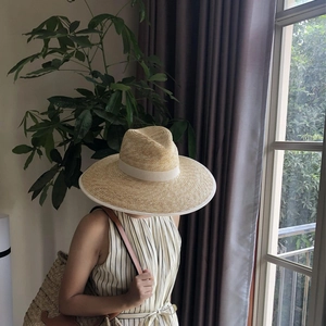 Detail of a 13cm wide brim straw hat with white ribbon trim for summer holiday style