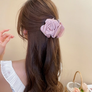 Dettaglio di un grande fermaglio per capelli a rosa rosa antico su un'acconciatura raccolta