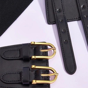 Close-up of black elastic corset belt featuring dual golden metal buckles and leather texture